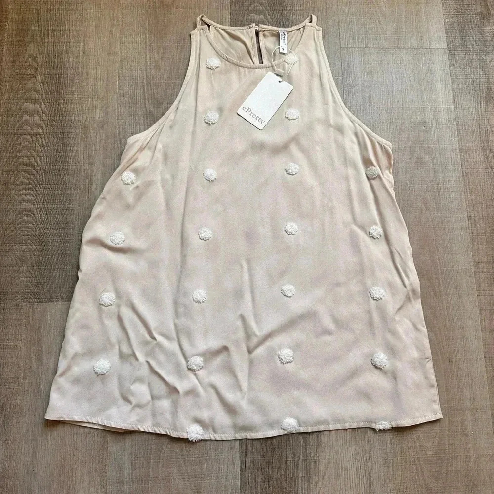 NWT, never worn cream tank with white Pom detail. Size Small